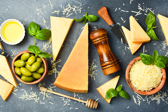 Top dow shot of different hard cheeses with olives and basil