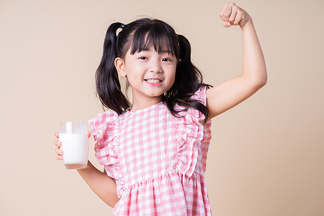 Young girl holding a glass of milk